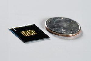 A close-up of Majumdar and Heide's optical computing chip next to a quarter, which is a similar size